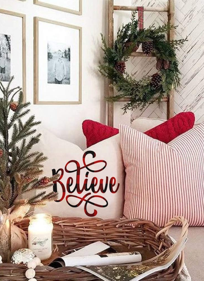 Christmas decor with mini tree, green wreath, ladder, two red Christmas pillows on couch