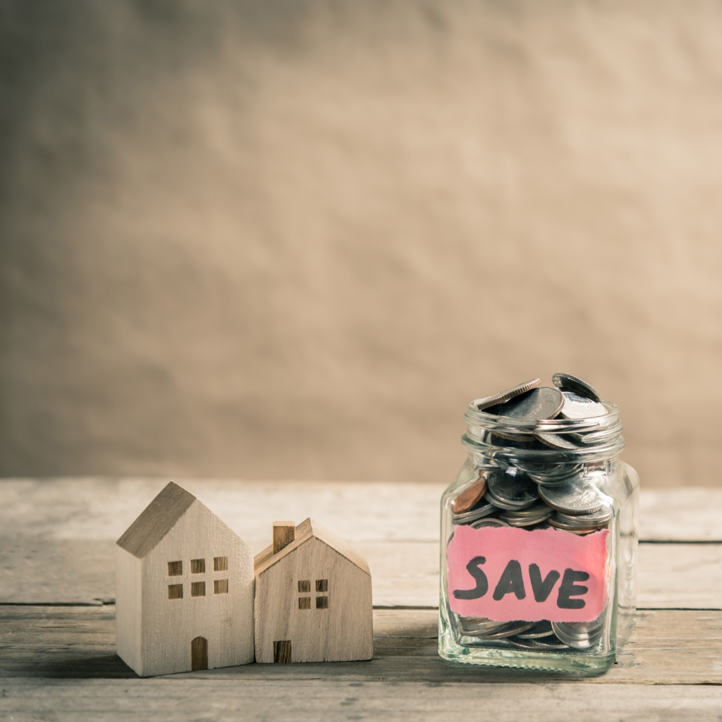 Small wooden houses and jar of coins for smart ways to use your tax return