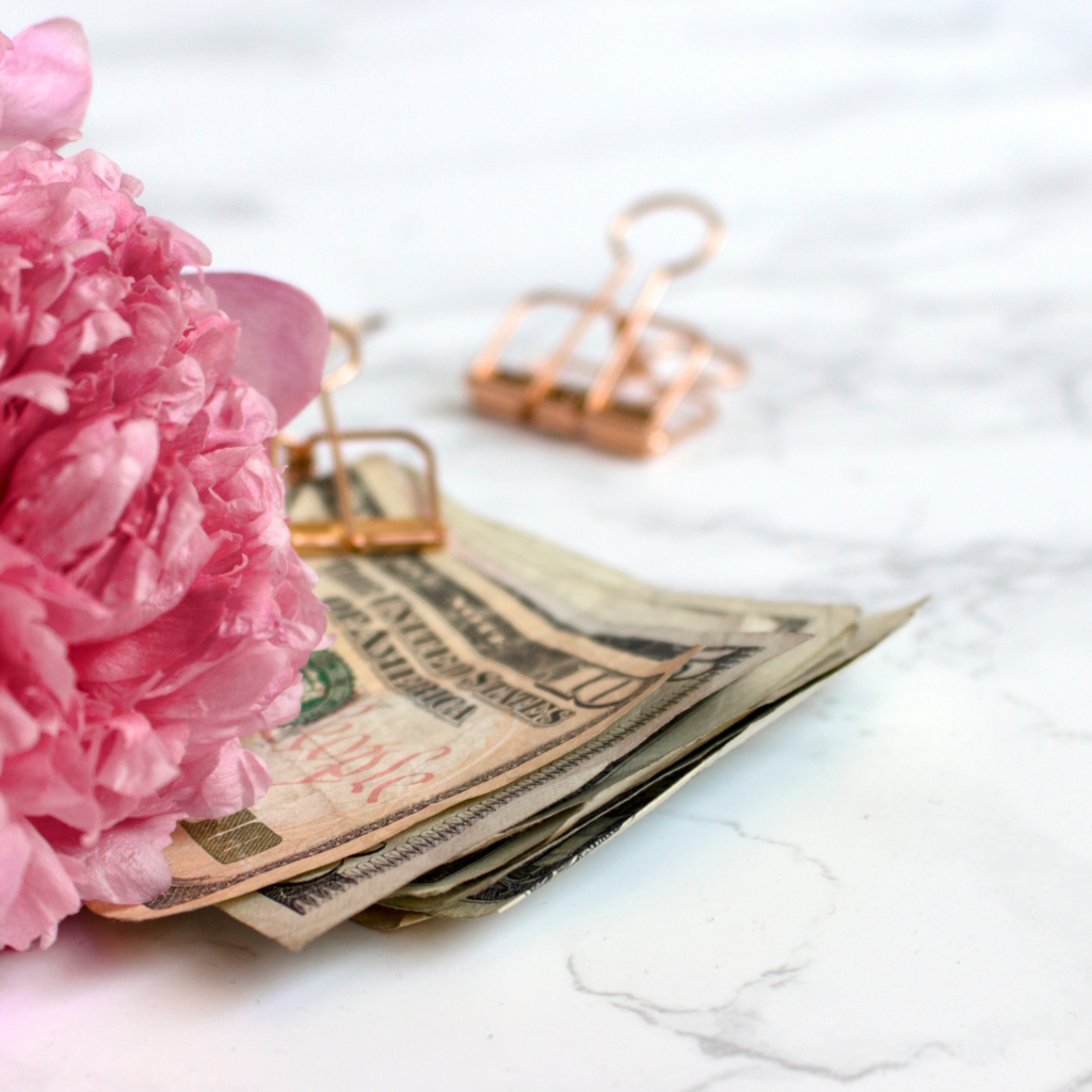Money, paperclip, and flower for 14 ways to kickstart financial spring cleaning