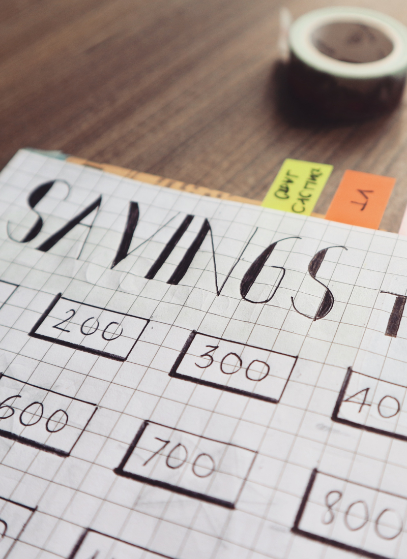 Paper with words saving Tracker written on it for how to save money on a low income