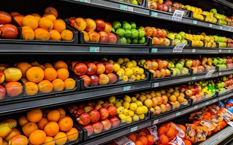 Rows of fruits at a grocery store for Cheap Foods To Buy When You're Broke & Hungry