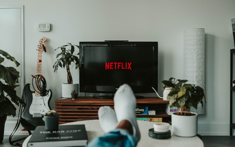 Person relaxing getting ready to watch Netflix. Photo credit Mollie Sivaram.
