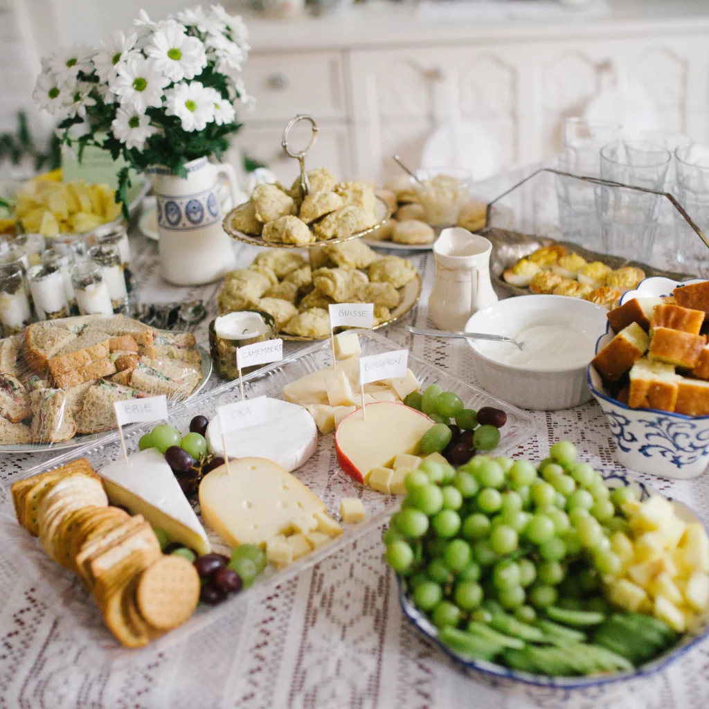 Food spread of sandwiches, charcuterie, fruit for baby shower food ideas on a budget