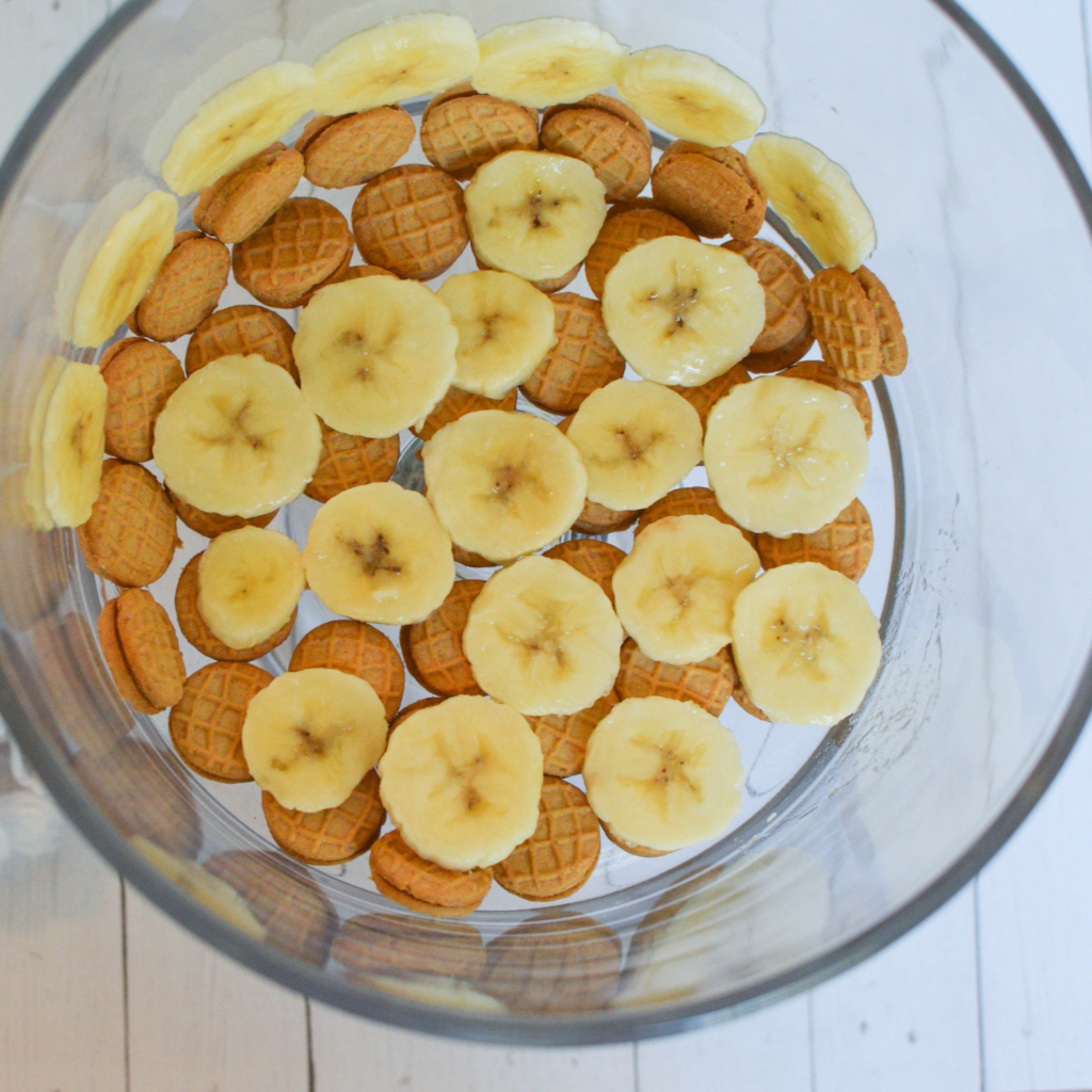 first step of laying bananas and cookies in trifle dish