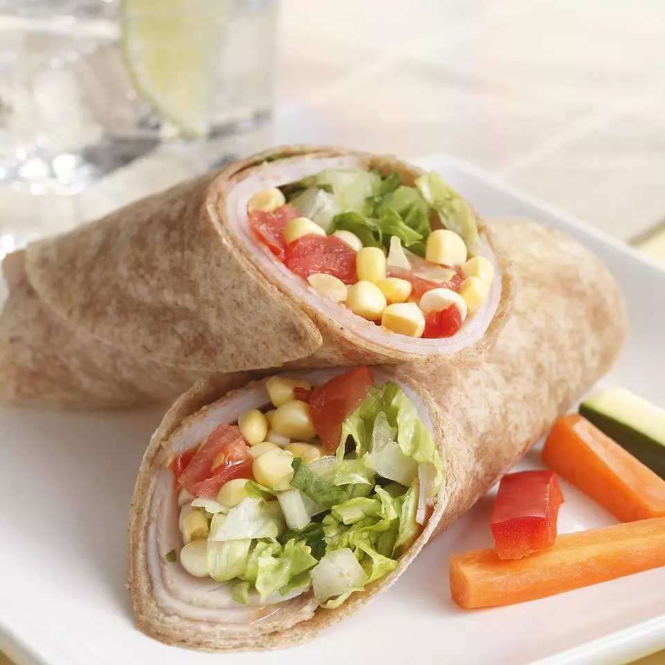Turkey wrap that includes corn, sun-dried tomatoes, and other vegetables.