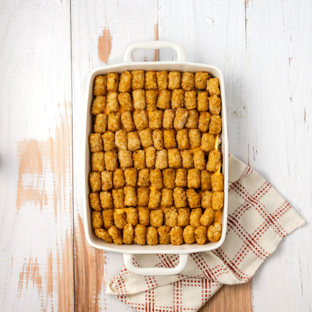 Casserole dish with beef mixture, cheese, Jalapeño, and tater tots