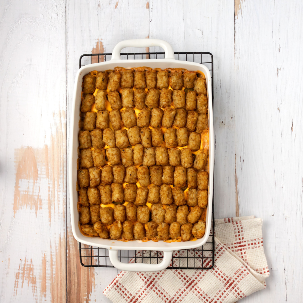 Casserole dish with beef, cheese, Jalapeño, and tater tots sitting on cooling rack