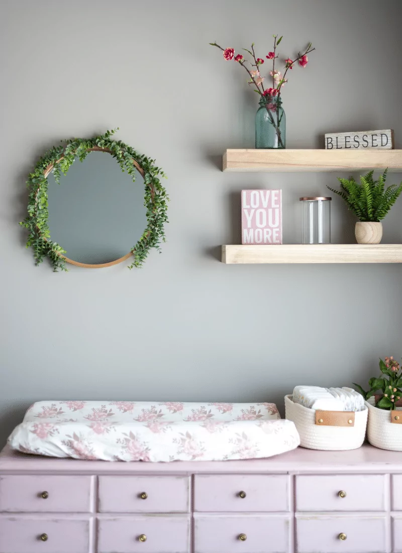 Mirror with affordable shelving and changing pad for baby room ideas on a budget.