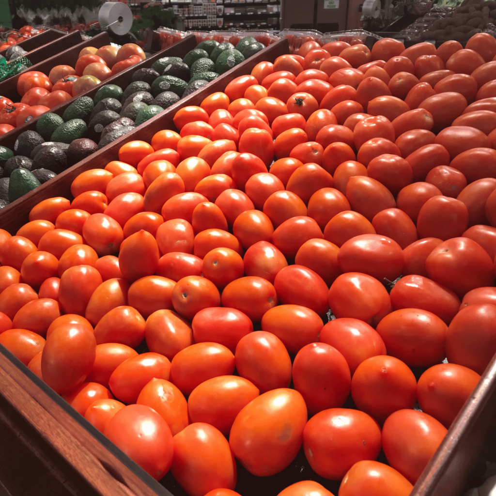 Tomatoes and other produce displayed in a grocery store