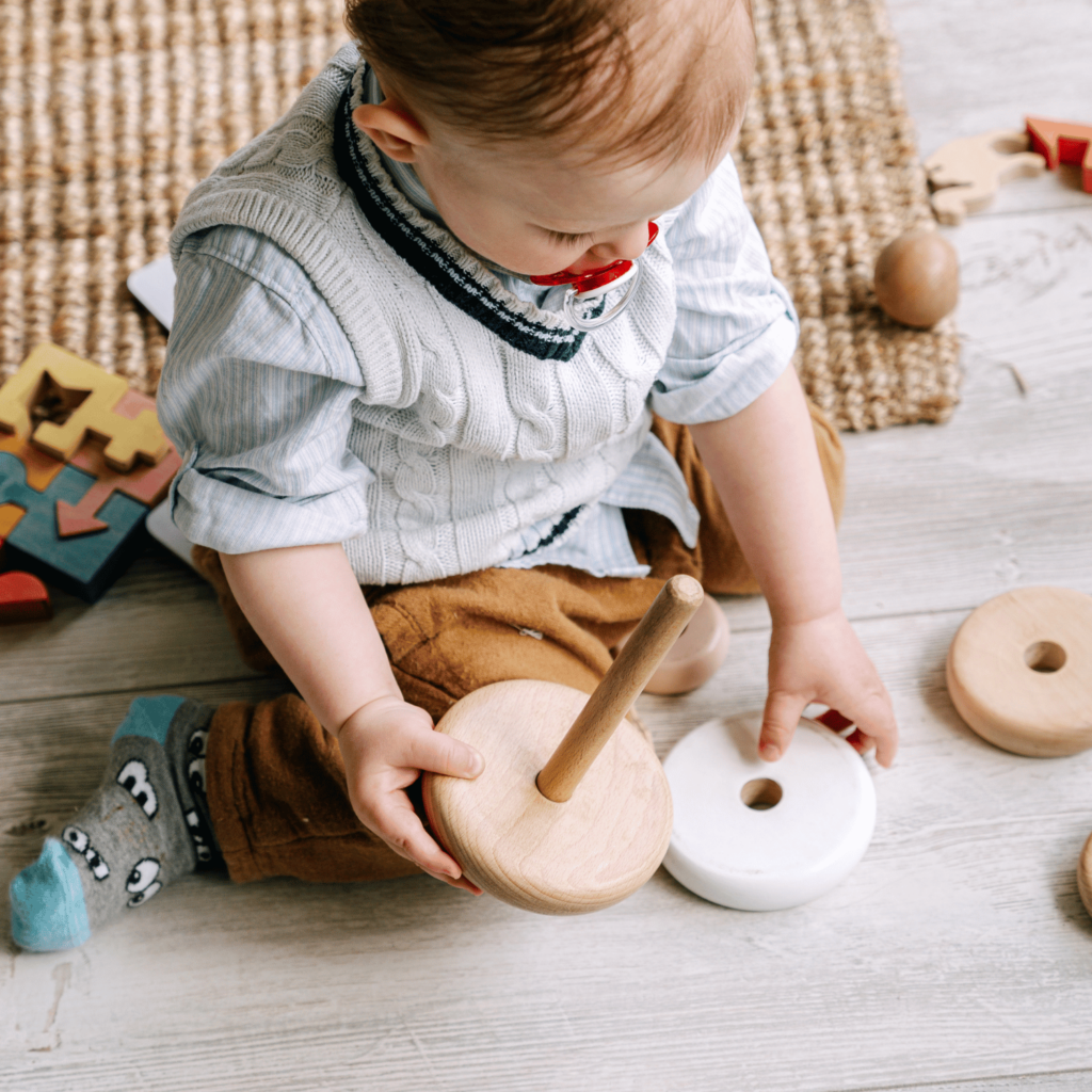 Baby playing with toys on the floor for baby budget worksheet