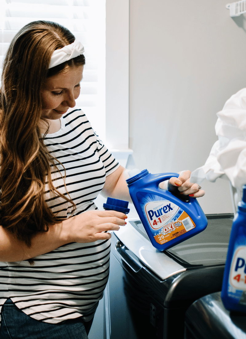 Woman pouring laundry detergent into cap on how to save money on laundry with